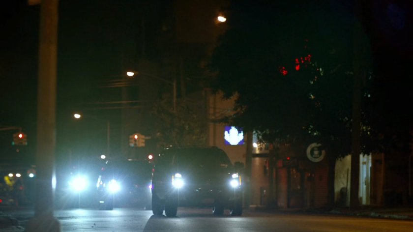Motorcade of black SUVs on New York street.