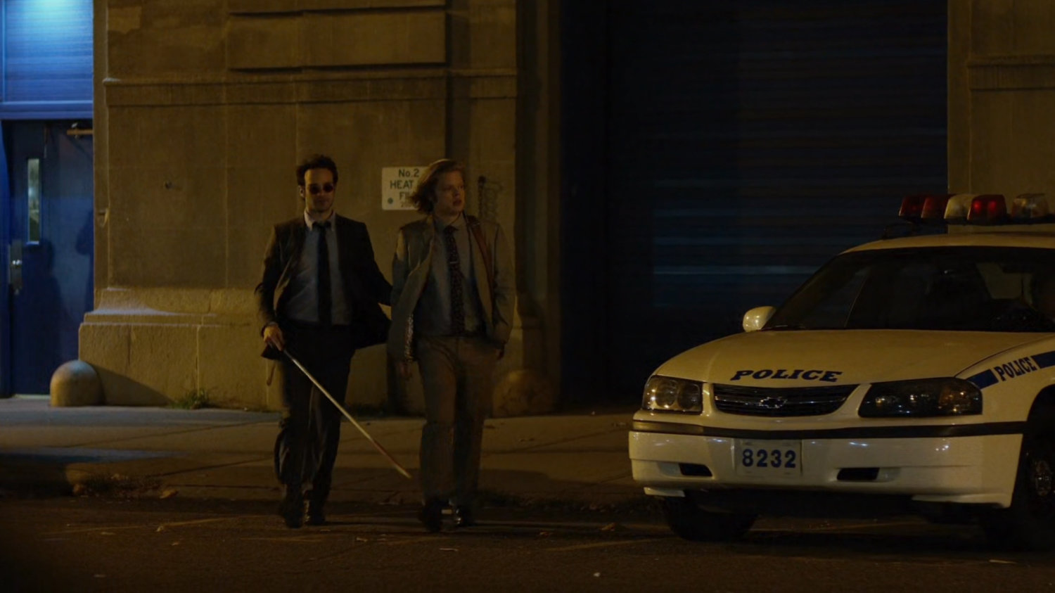 Matt and Foggy on sidewalk outside of 15th precinct at night.
