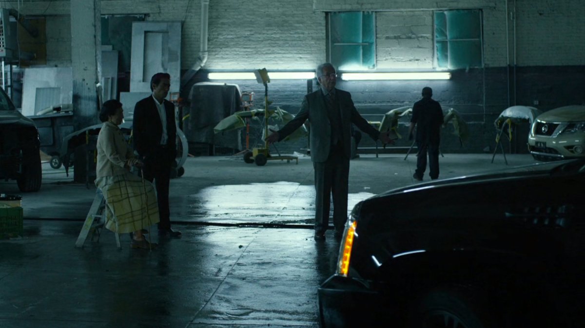 Madame Gao, Nobu, and Leland in body shop garage.