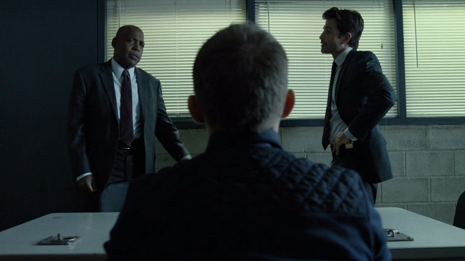 Blake and Hoffman with suspect in interrogation room.