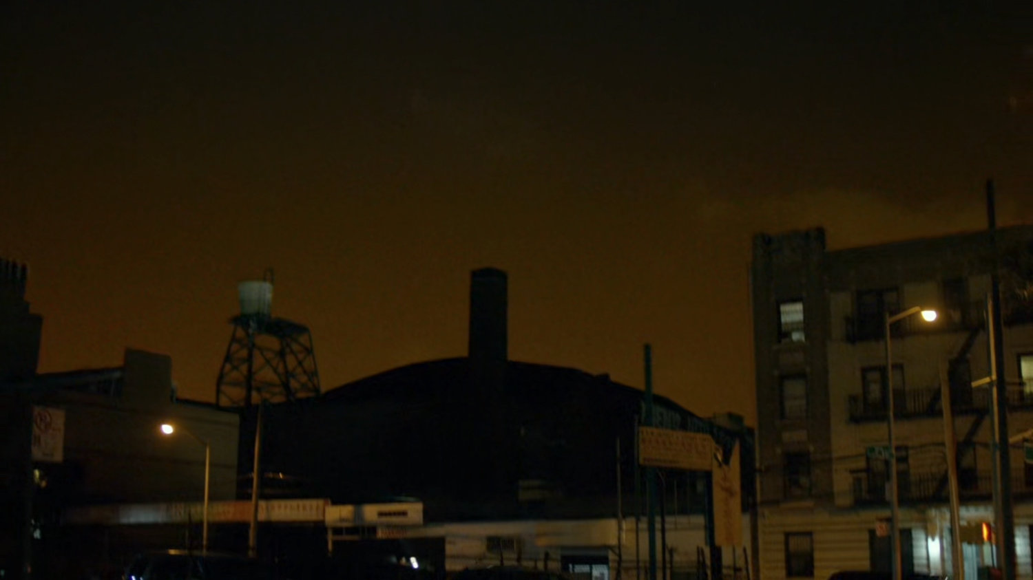 Night time shot of rooftops and intersection of New York.