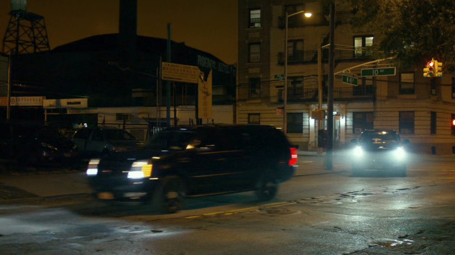 Night time shot Fisk motorcade turning corner at intersection of New York.
