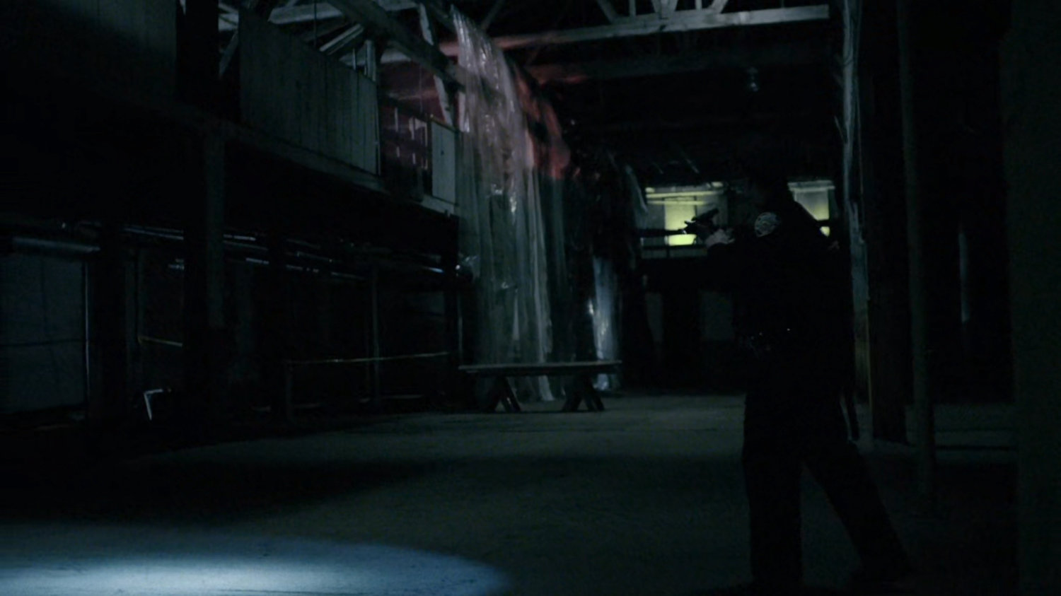Police officer inside abandoned warehouse.