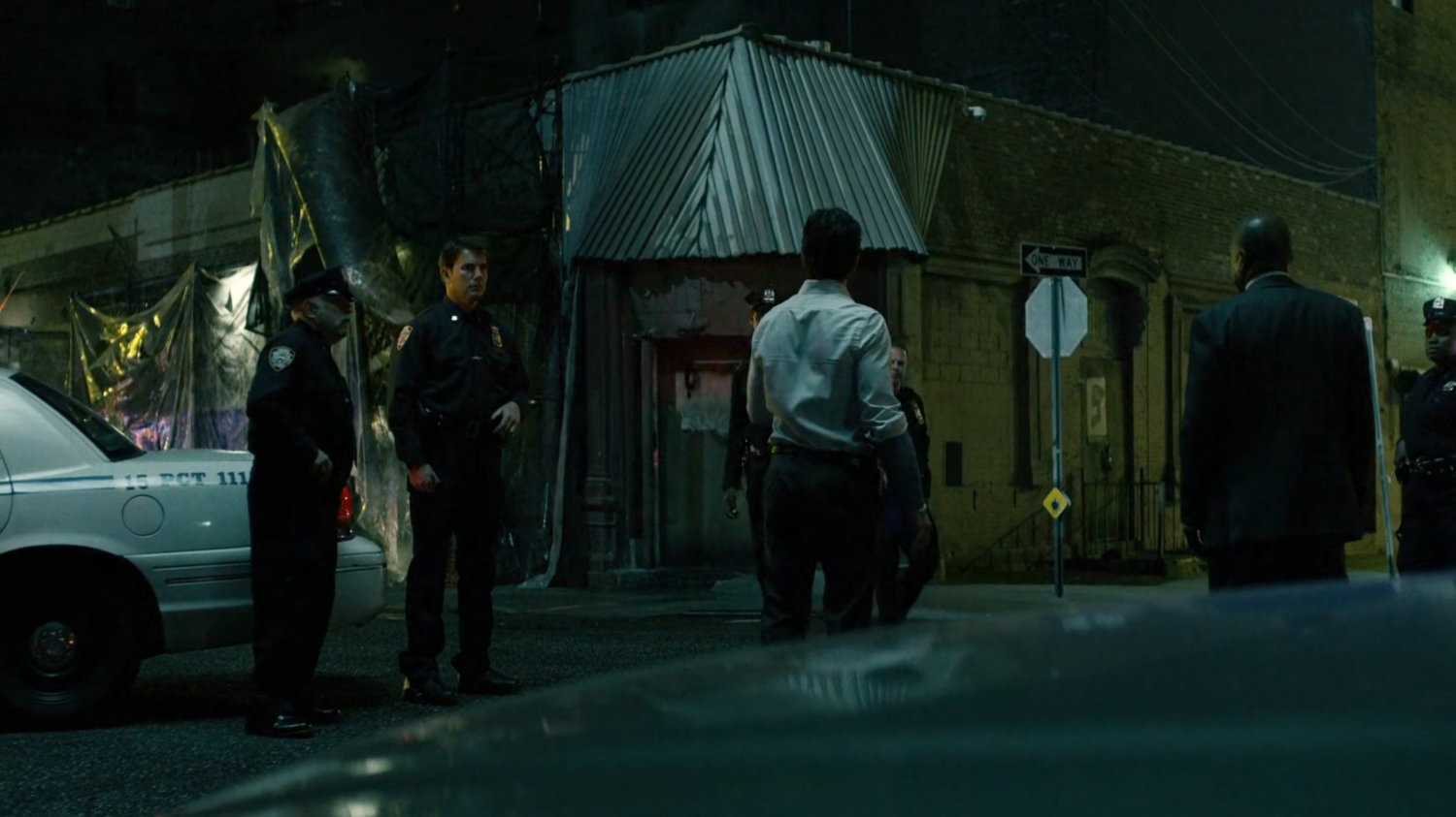 Police officers outside of abandoned warehouse.