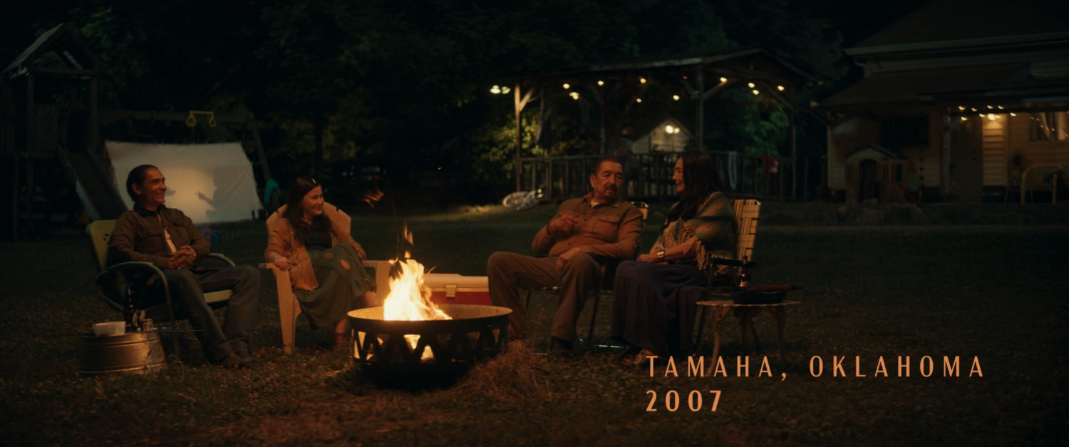 William, Taloa, Skully, and Chula sit around a campfire. Text: Tamaha, Oklahoma, 2007.