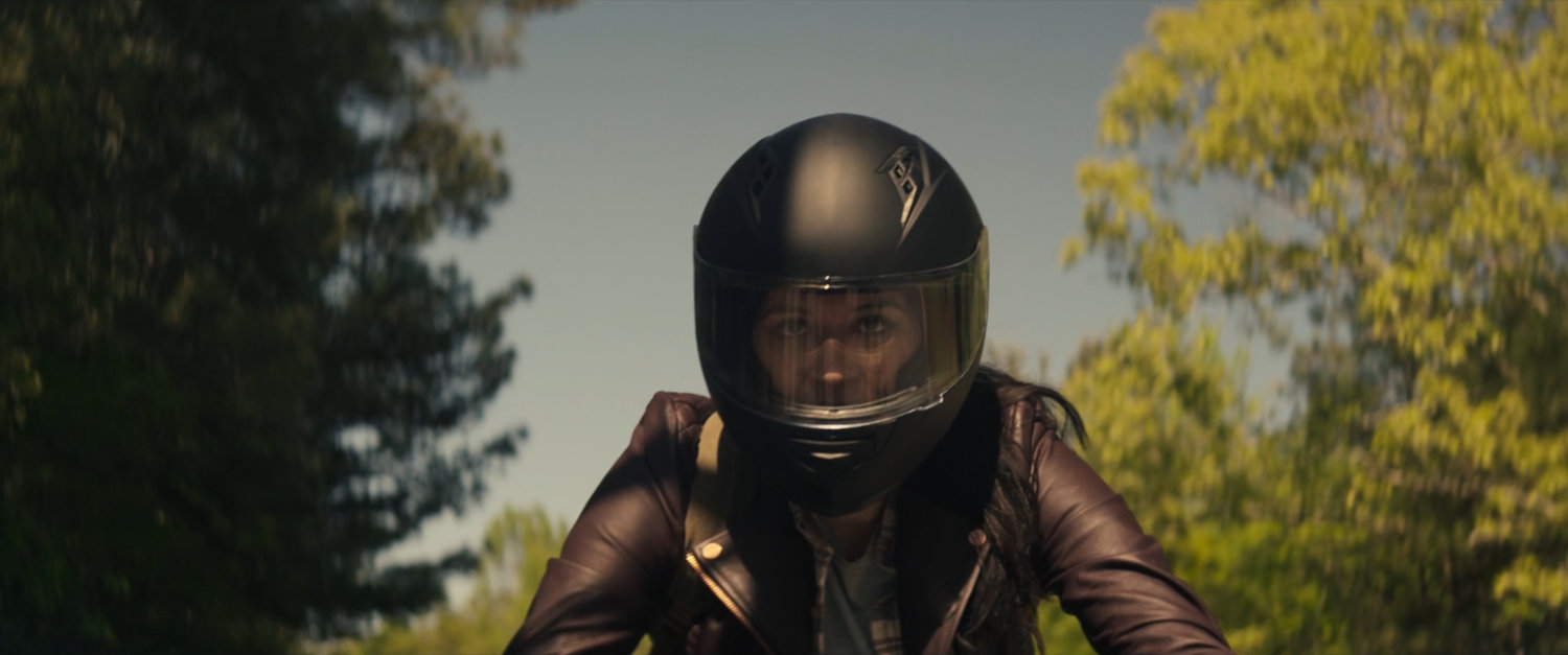 Maya on motorcycle on country road.