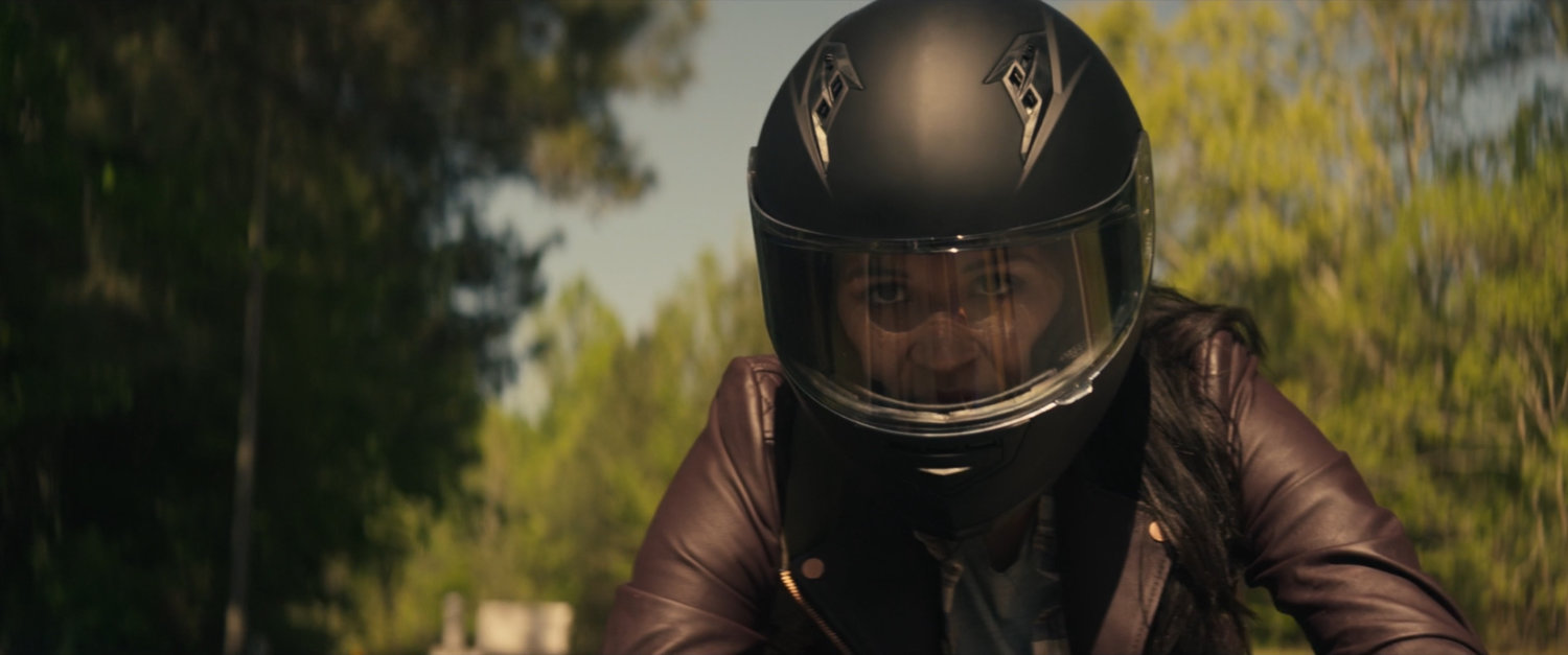 Maya on motorcycle on country road.