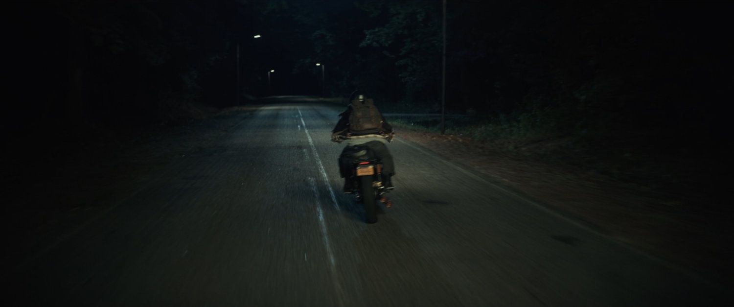 Motorcycle on country road at night.