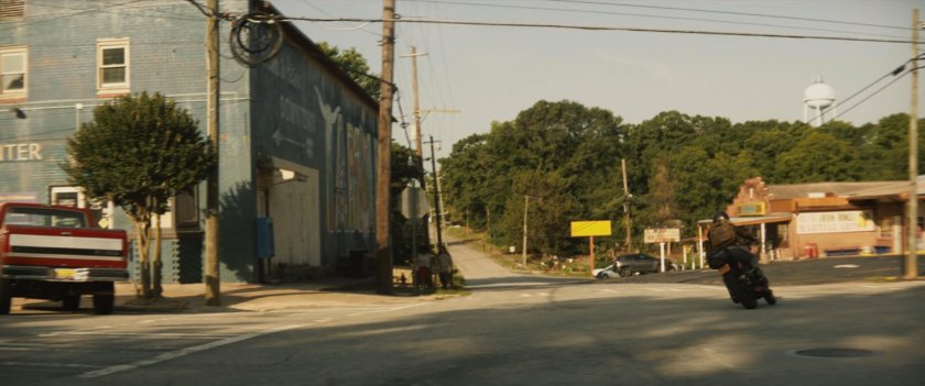 Maya on motorcycle turning corner in downtown Tamaha.