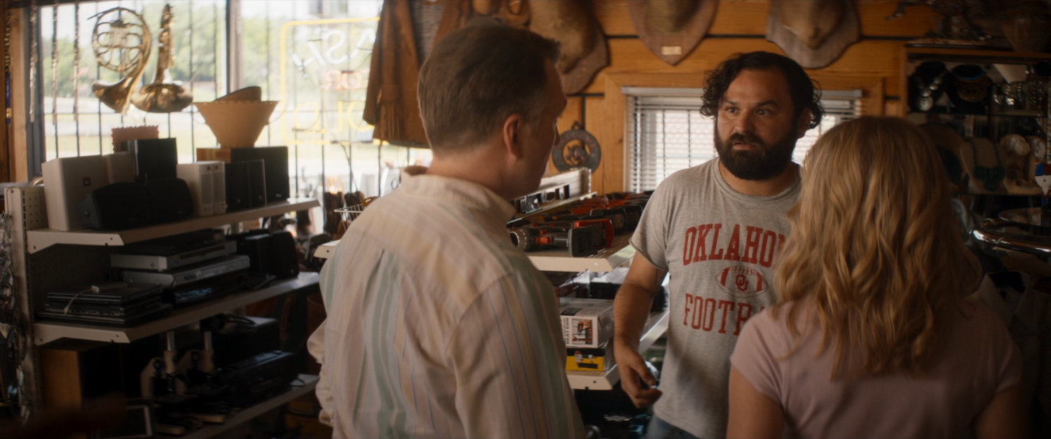 Biscuits talks to two tourists inside Skully's Pawn shop.