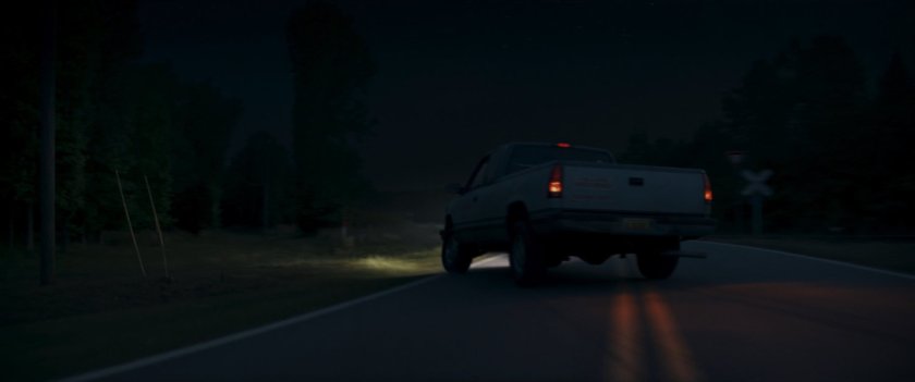 Pickup truck veering off highway at night.