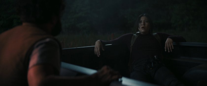 Maya in pickup in field at night.