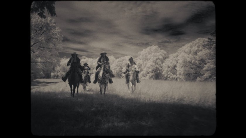 Lighthorsemen riding across field.