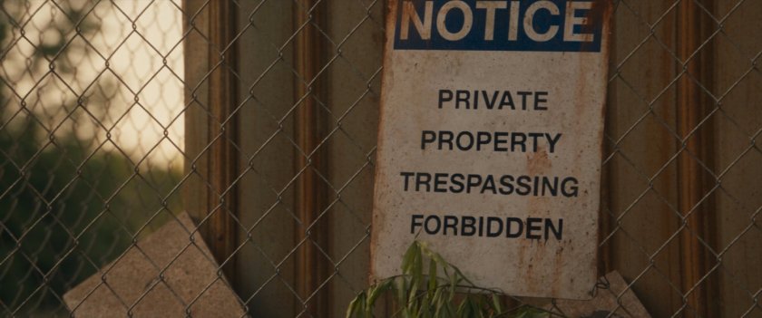 Sign outside fenced in field. Text: Notice Private Property Trespassing Forbidden.