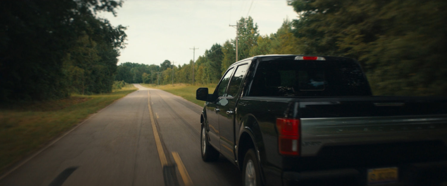 Pickup truck on country road.