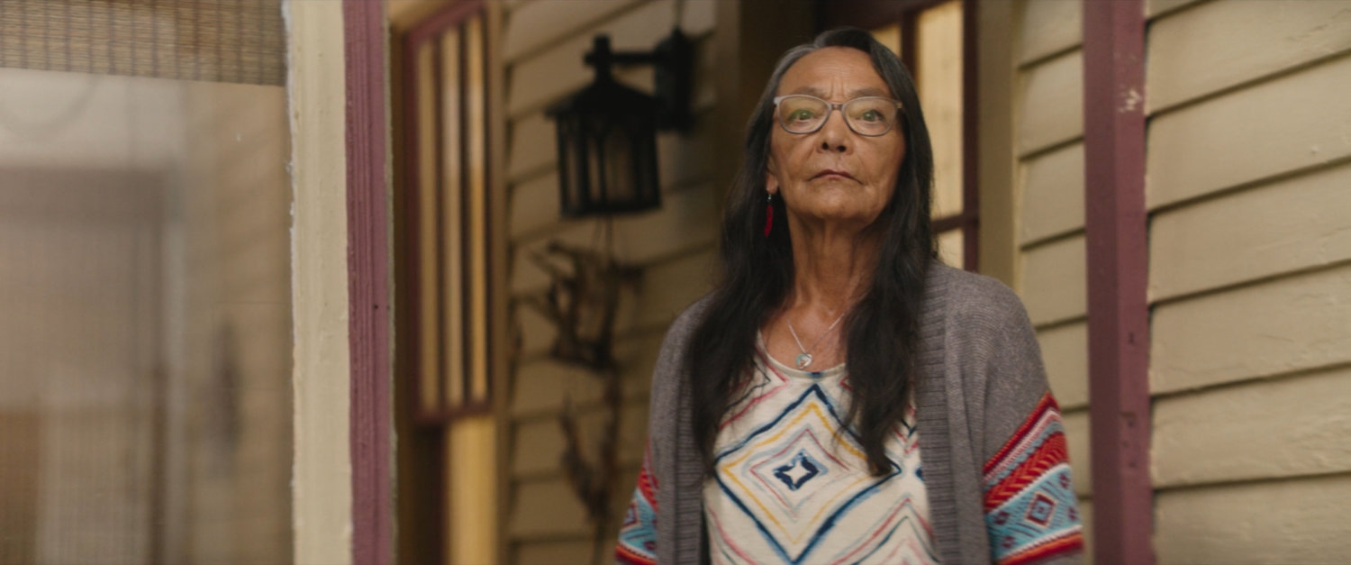 Chula standing outside of her house.