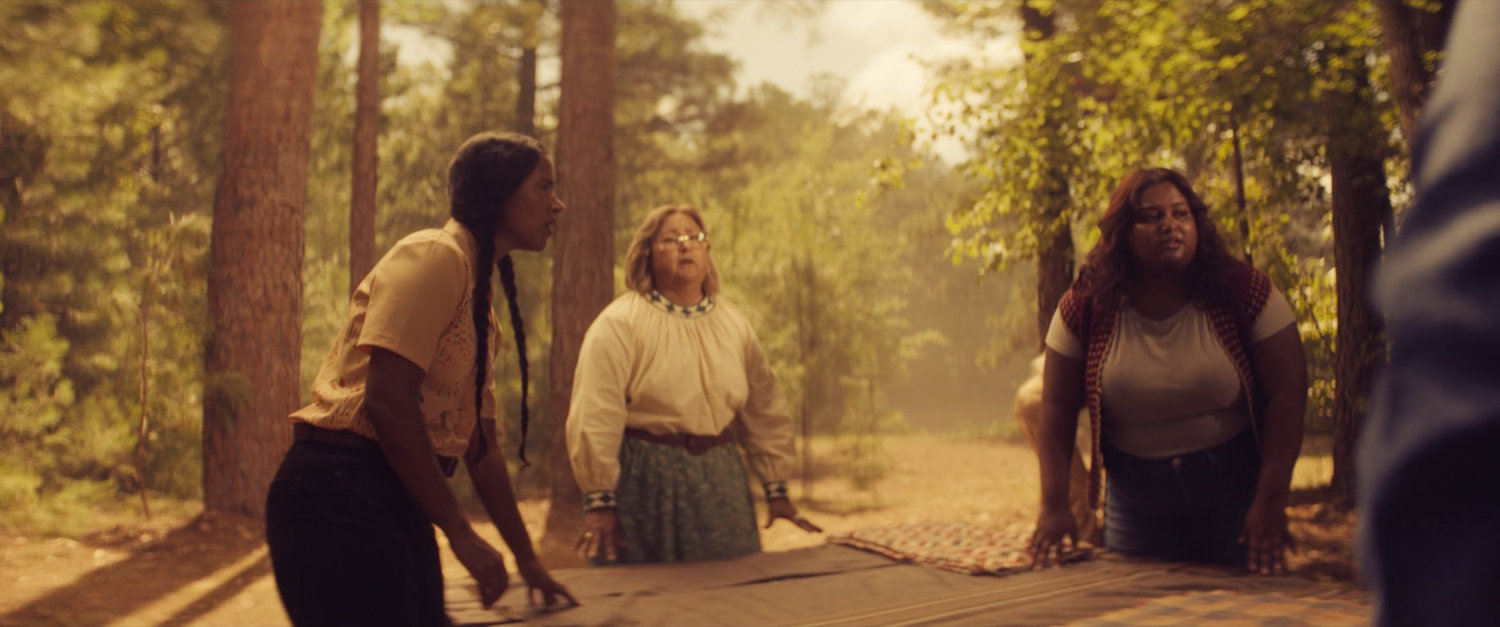 Women gather around young Chula giving birth in woods.