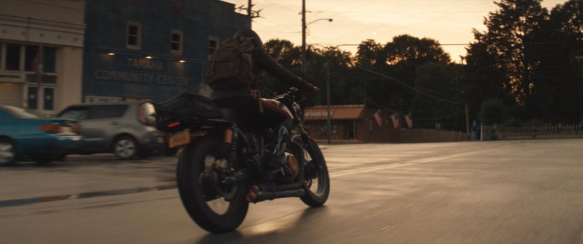 Maya on motorcycle turning corner in downtown Tamaha.