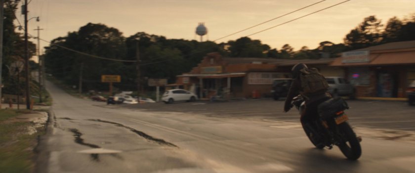 Maya on motorcycle turning corner in downtown Tamaha.