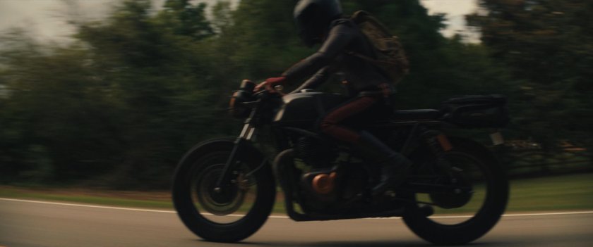 Maya on her motorcycle on a country road.