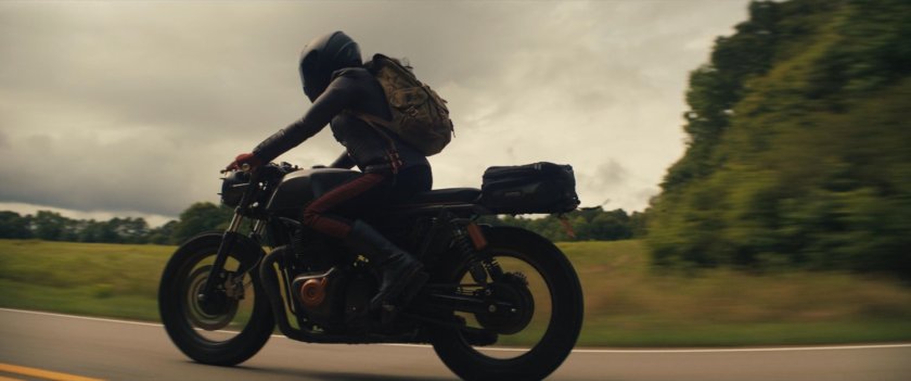Maya on her motorcycle on a country road.