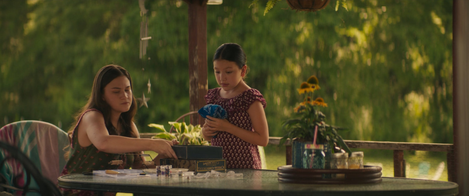 Taloa and Young Maya look at a wounded woodpecker at the Lopez House.