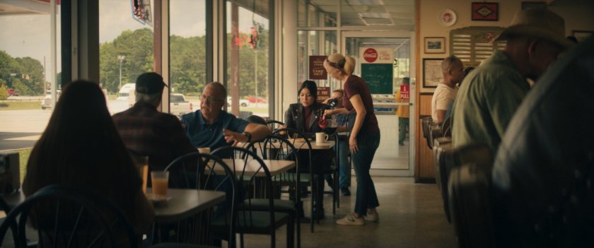 Waitress pouring coffee for Maya inside of Roxxon Travel Store restaurant.