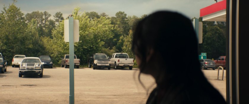 Maya looking out window of Roxxon Travel Store restaurant.