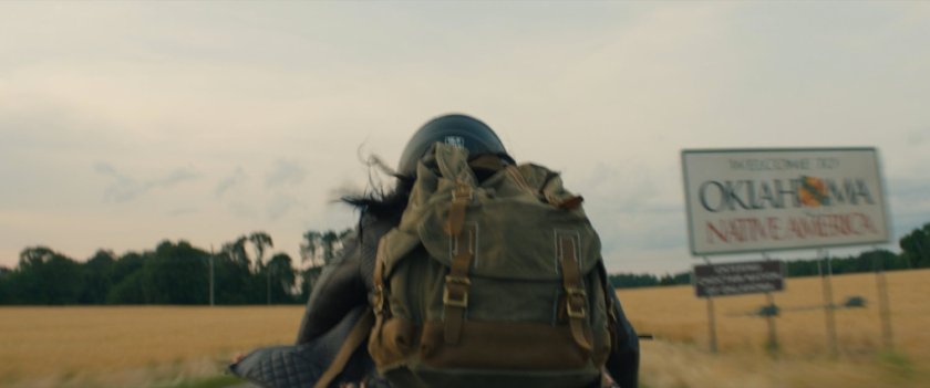Motorcycle on country road. Sign: Welcome to Oklahoma Native America.