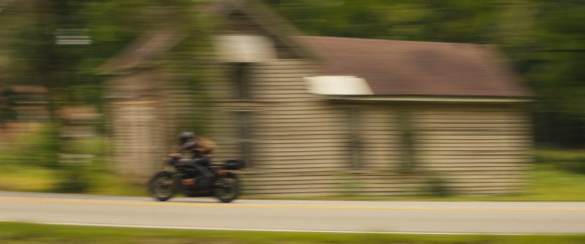 Maya on motorcycle driving out of downtown Tamaha.