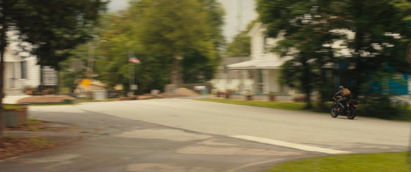 Maya on motorcycle driving out of downtown Tamaha.
