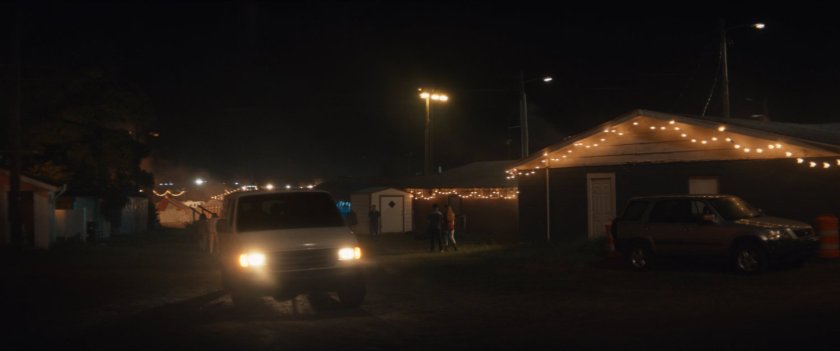 Vans pull through the Choctaw Nation PowWow at night.