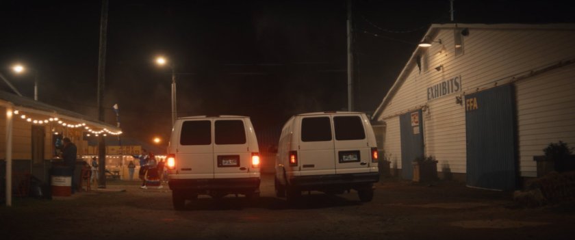 Vans pull through the Choctaw Nation PowWow at night.