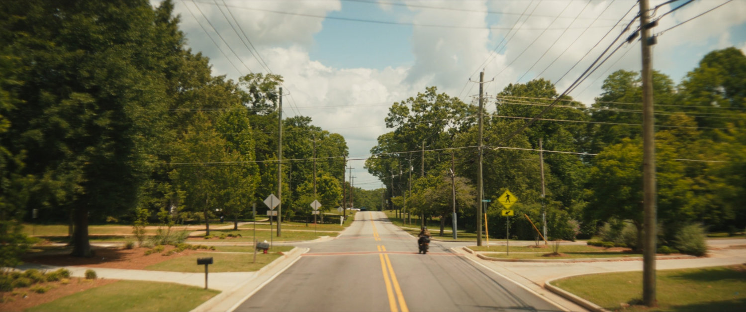 Maya racing away on a Tamaha street on her motorcycle.