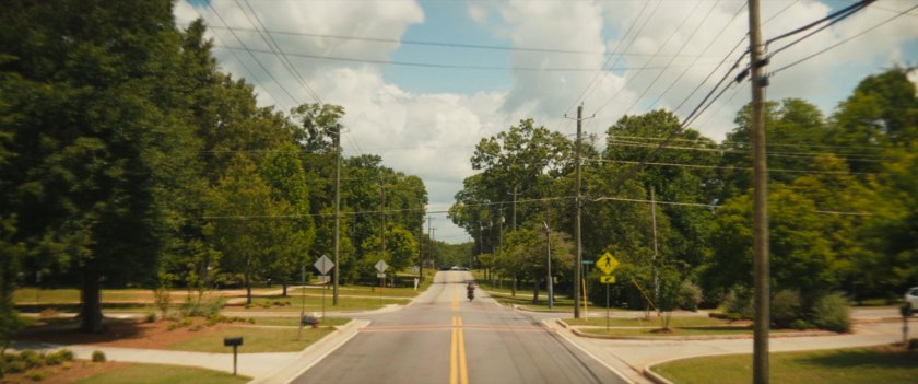 Maya racing away on a Tamaha street on her motorcycle.