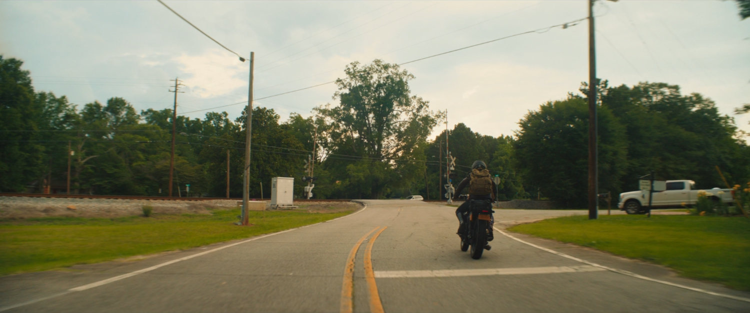 Maya's motorcycle on a Tamaha street going over a train crossing.
