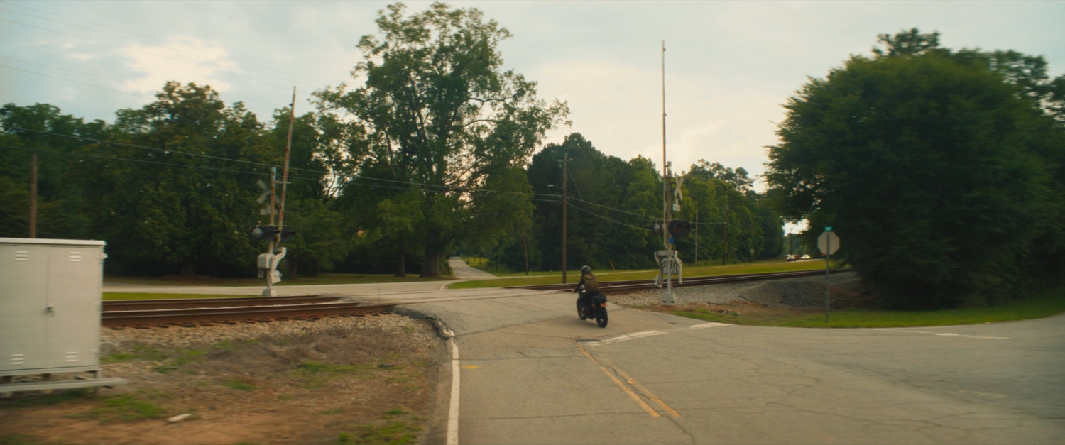 Maya's motorcycle on a Tamaha street going over a train crossing.