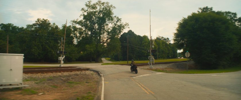 Maya's motorcycle on a Tamaha street going over a train crossing.