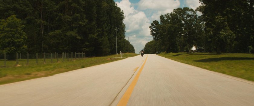 Maya on her motorcycle on a country road.
