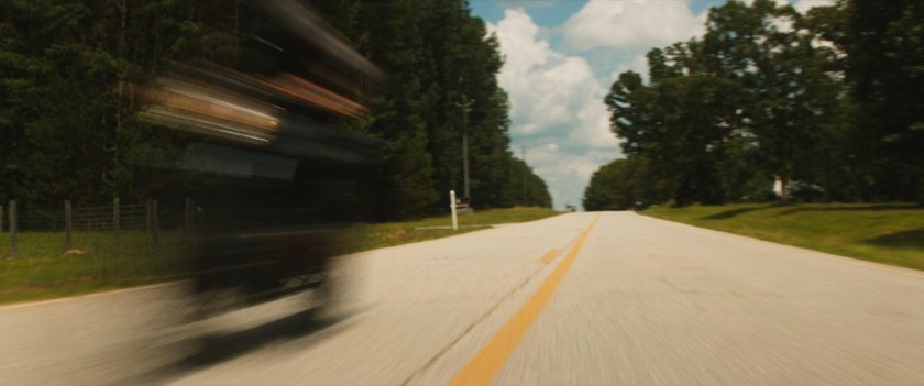 Maya on her motorcycle on a country road.