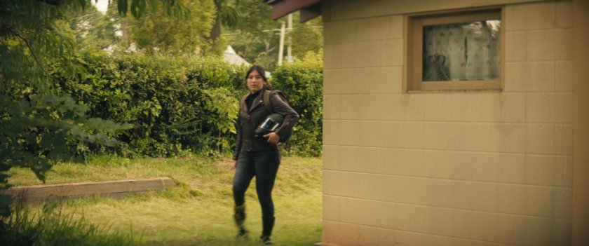 Maya walking around the side of Chula's house into backyard.