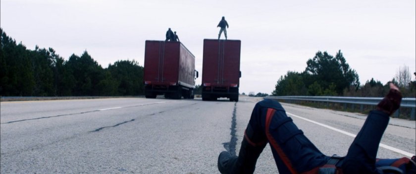 Behind the scenes view of trucks driving away from a fallen John Walker.