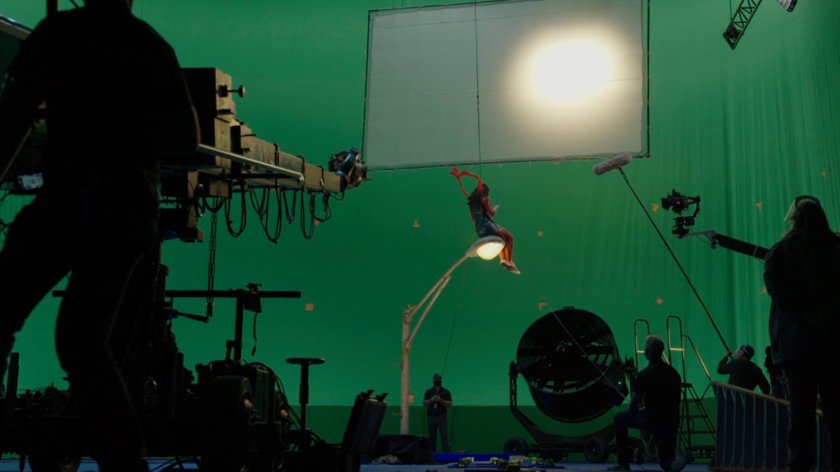 Behind-the-scenes shot of Kamala sitting on street light with New York in the background.