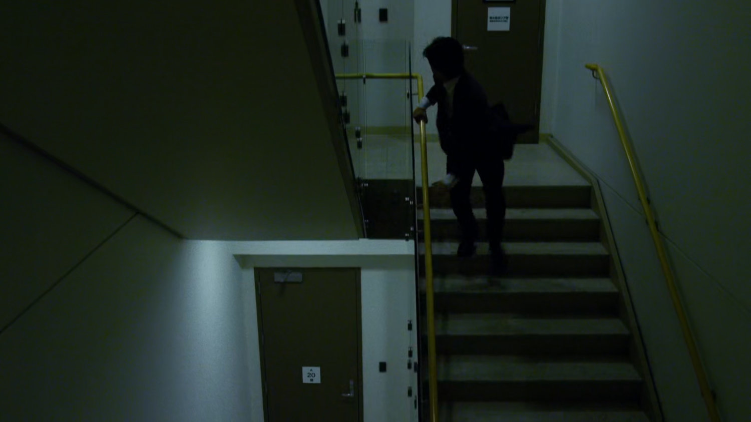 Aito runs down stairwell in Tokyo office building.