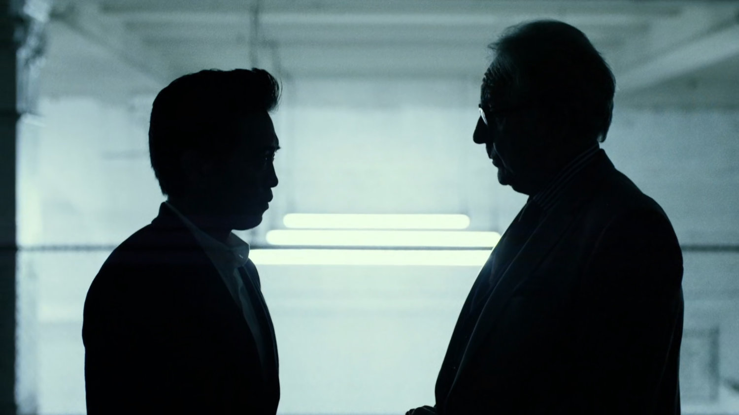 Nobu and Owlsley in stark white parking garage.