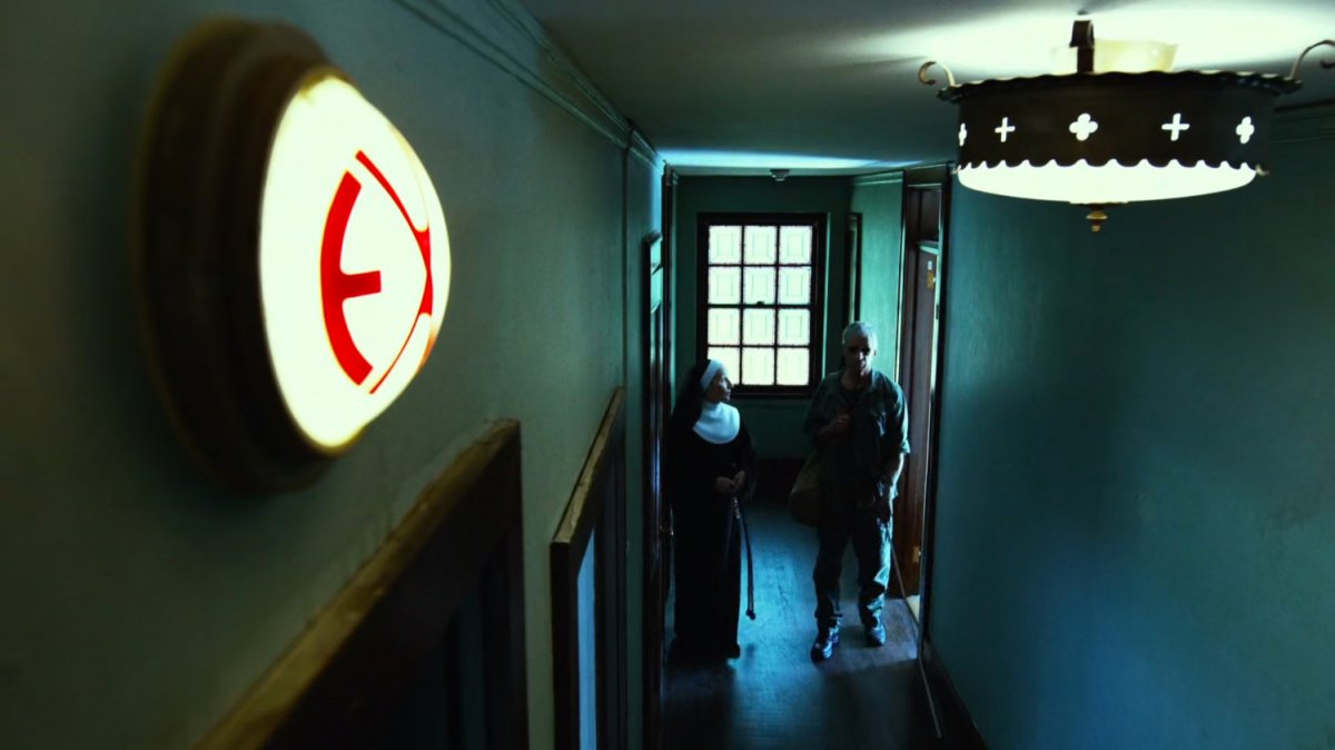 A nun escorts Stick down an orphanage hall.