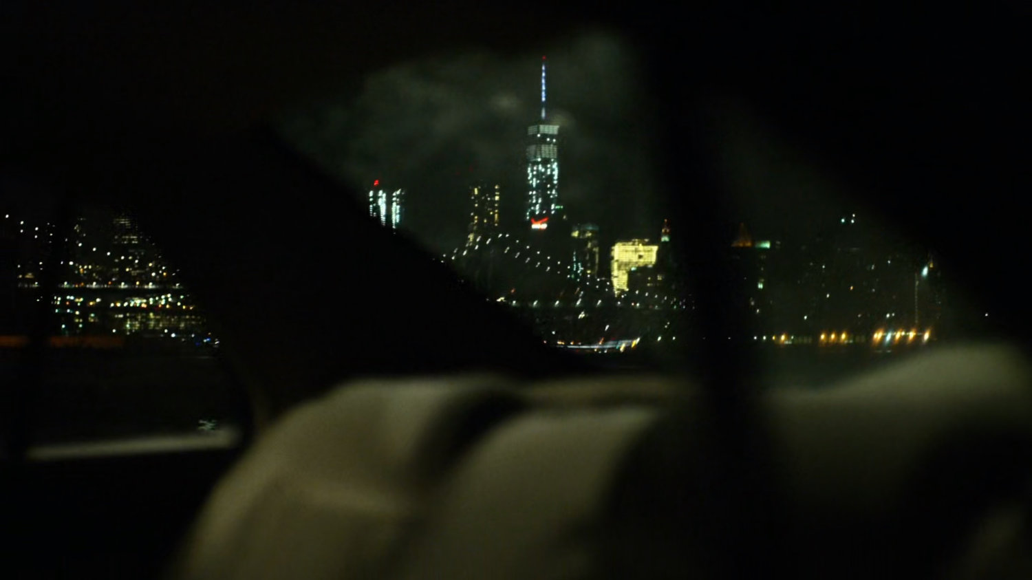 View of downtown Manhattan at night from window of car.