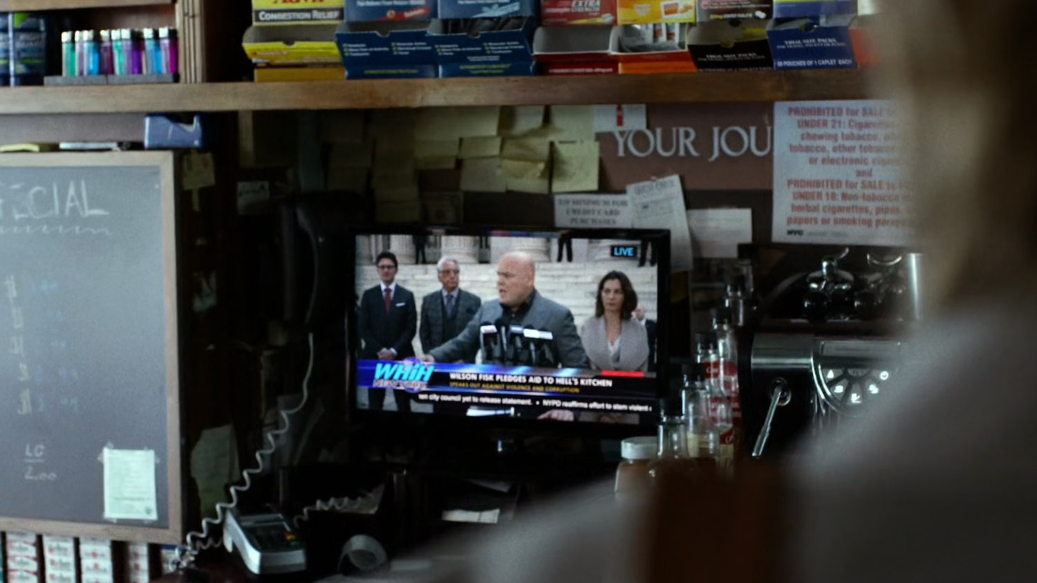 Interior of bodega with Wilson Fisk televised press conference.