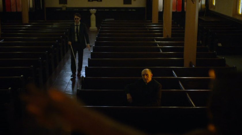 Matt and Father Lantom in church pews.