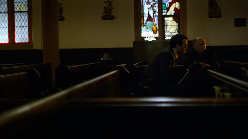 Matt and Father Lantom in church pews.